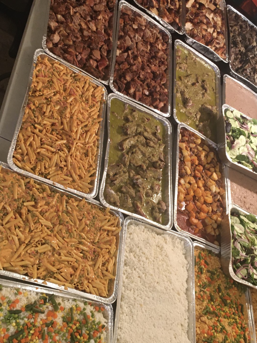 Mesa de catering con pastas, carnes y ensaladas